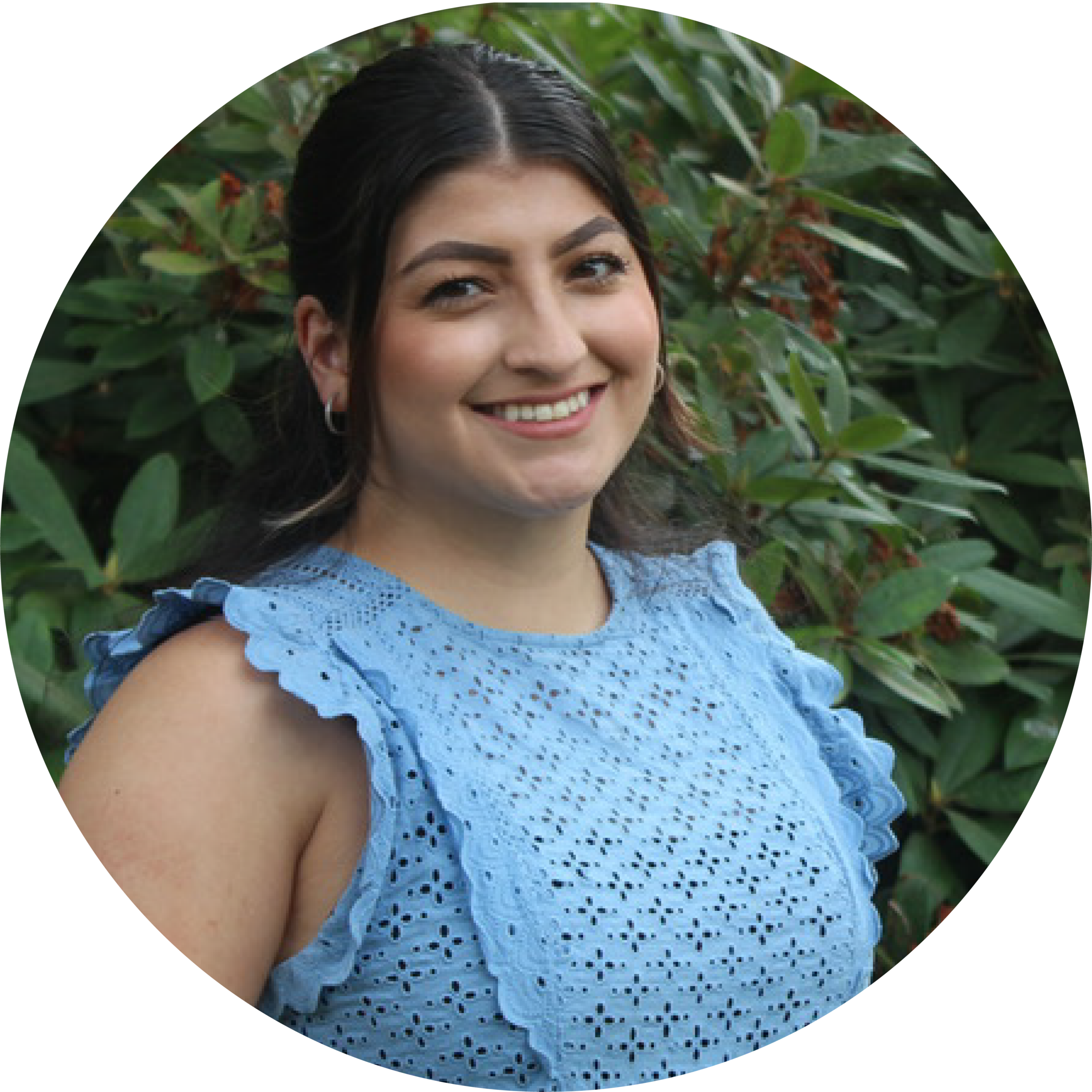 Smiling person in a blue dress outdoors.